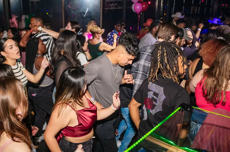 People dancing under club lights in VIBES at Stampede Houston